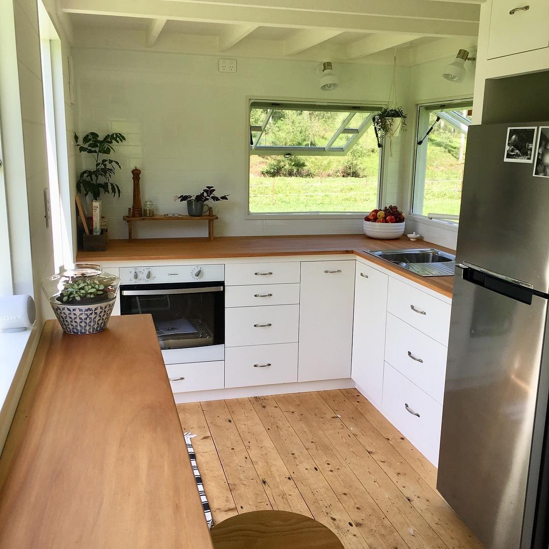 10. Bright White Corner Kitchen With Natural Wood Counters - tiny house kitchen ideas