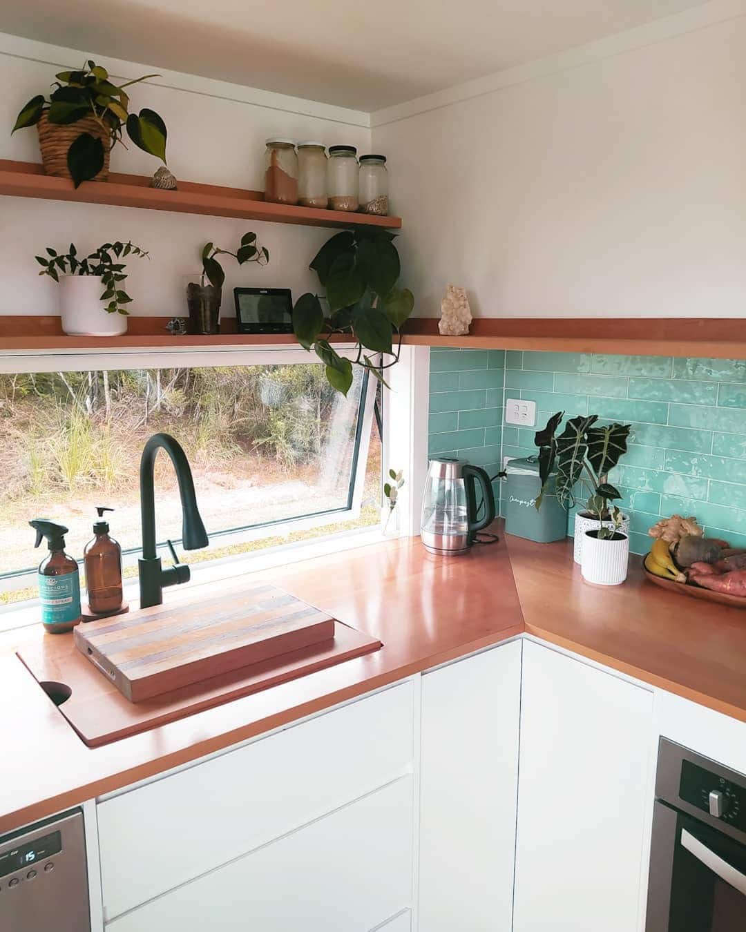 19. Cozy Corner Kitchen With Teal Tile and White Cabinetry - tiny house kitchen ideas