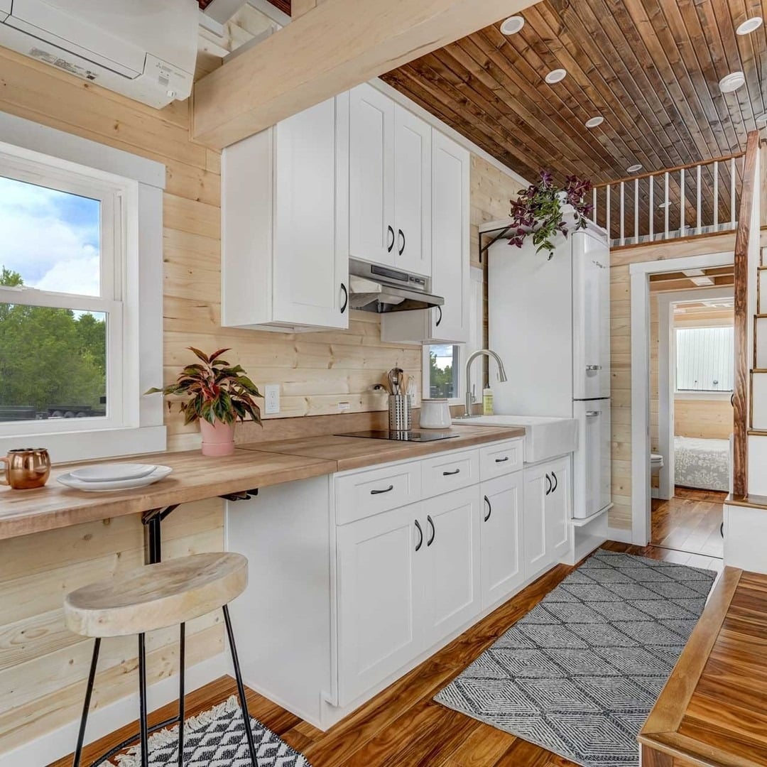20. Warm White Kitchen With Timber Counters and Loft Storage - tiny house kitchen ideas