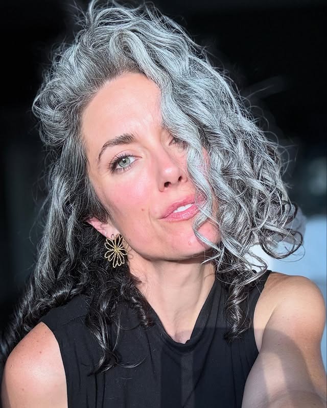 20. Curly Salt-and-Silver Contrast with Voluminous Side Sweep - Gray Hairstyles for Women