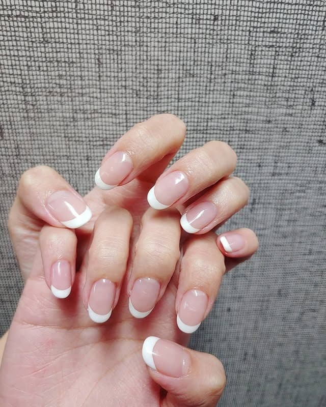 11. Rounded Classic French with Bright White Tips - white french nail ideas
