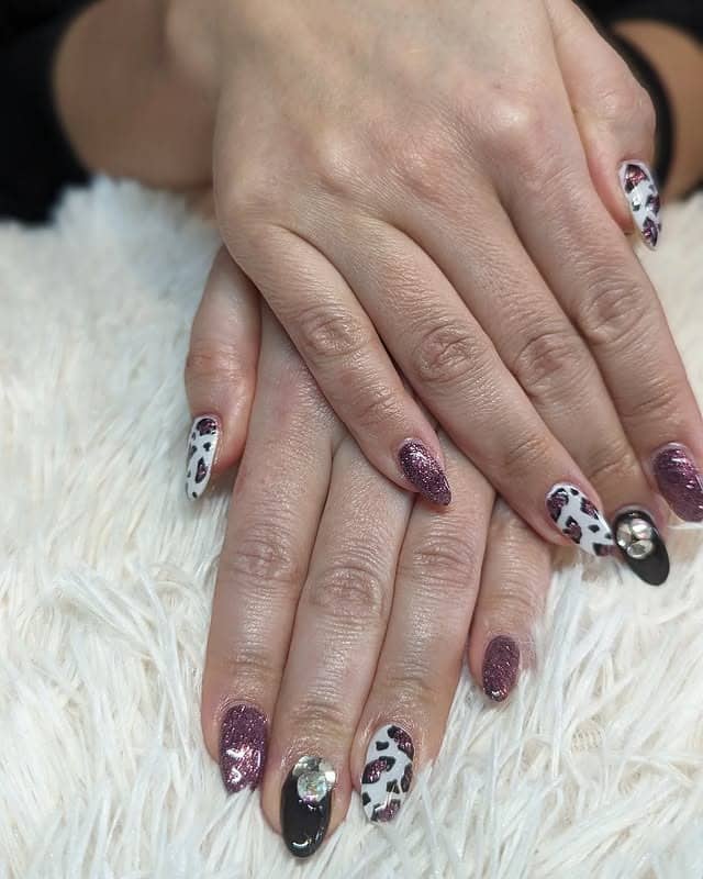 10. Purple Sparkle With Heart-Shaped Cow Prints - animal nail ideas