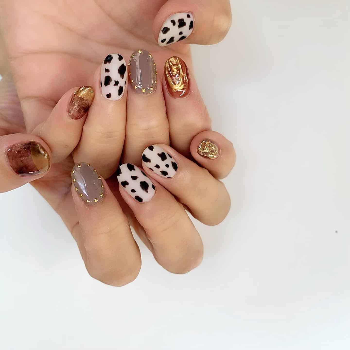 14. Golden Cow Print With Neutral Marbling - animal nail ideas