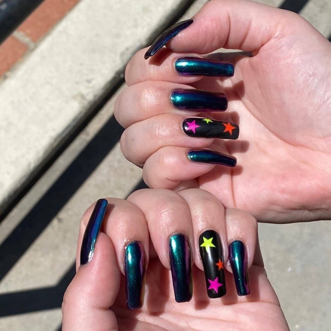 1. Electric Chrome with Neon Star Accents - black chrome nail ideas