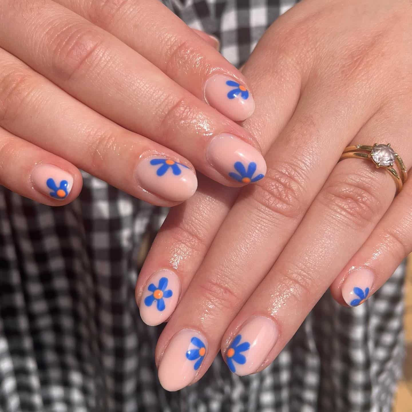 1. Soft Nude Nails with Bold Blue Blossoms - blue flower nail ideas