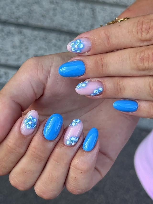 3. Vivid Blue Polish with Accent Floral Details - blue flower nail ideas