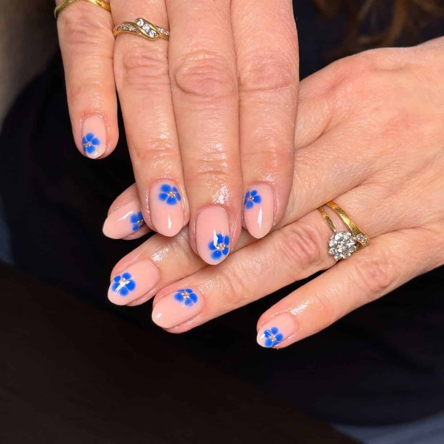 8. Classic Nude Base with Deep Blue Blossoms - blue flower nail ideas