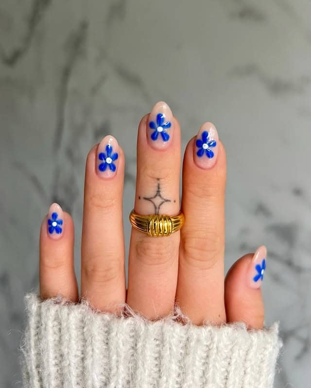 9. Minimal Nude Nails with Royal Blue Petals - blue flower nail ideas