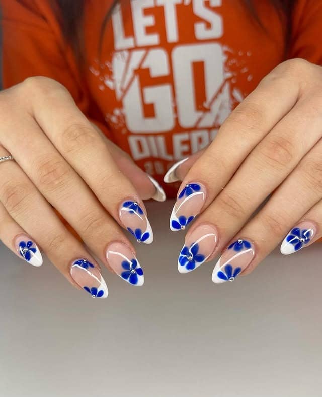 12. White-Edged French Nails with Deep Blue Petals - blue flower nail ideas
