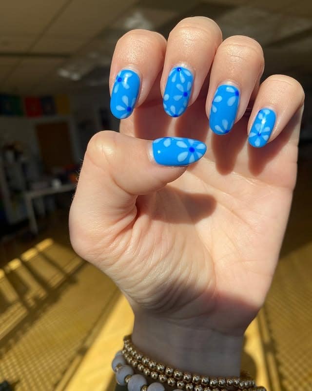13. Sky Blue Matte Nails with Soft Petal Patterns - blue flower nail ideas