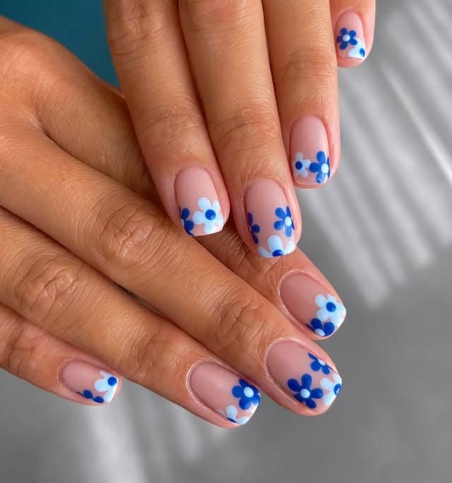 17. Short Nude Nails with Blue and White Daisy Clusters - blue flower nail ideas