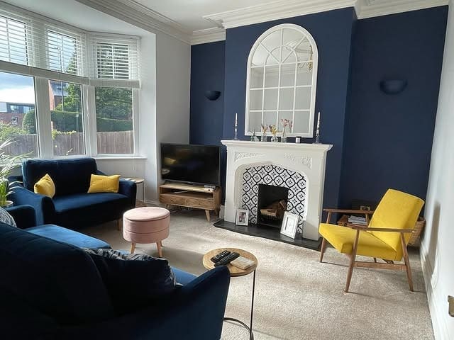 12. Cozy Navy Fireplace Setting with Mustard Highlights - yellow and blue living room ideas