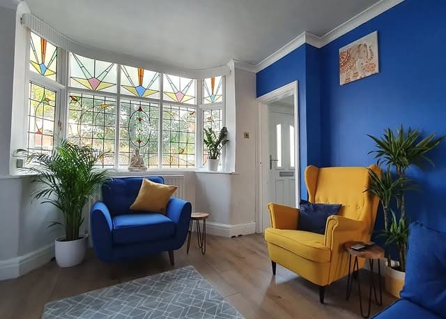 13. Stained Glass Charm with Bright Blue and Yellow Seating - yellow and blue living room ideas