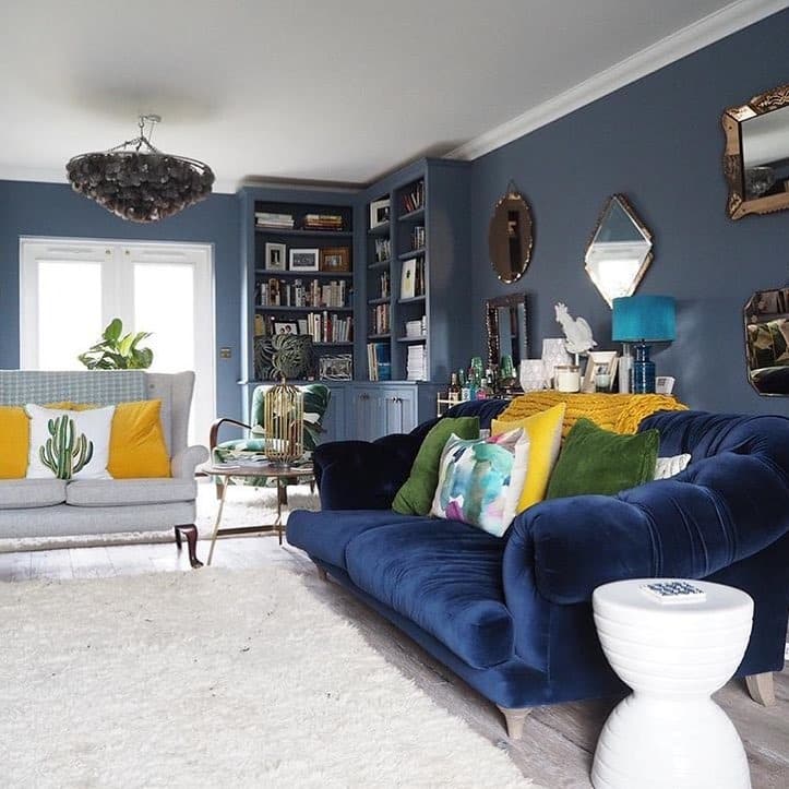22. Deep Blue Library-Style Lounge with Playful Yellow Cushions - yellow and blue living room ideas