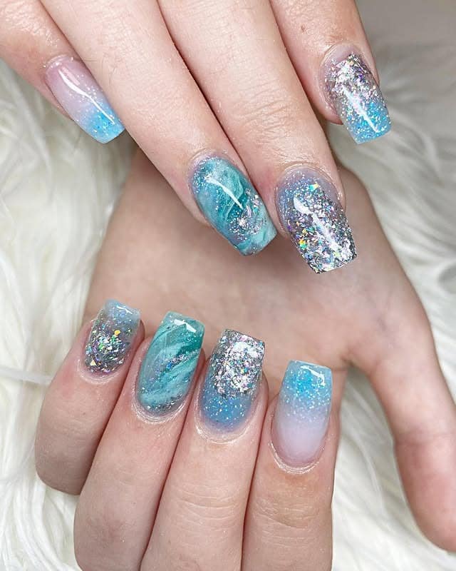 10. Blue Glitter Coastal Marble Nails - blue summer nail ideas