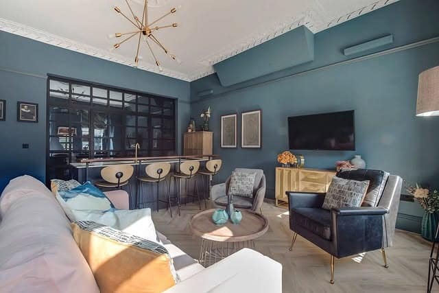 9. Deep Teal Lounge with Brass Bar Detailing - open lounge kitchen ideas