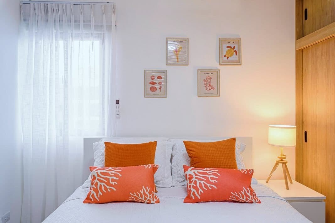 2. Modern Coral Pop in a Clean White Setting - coral bedroom ideas