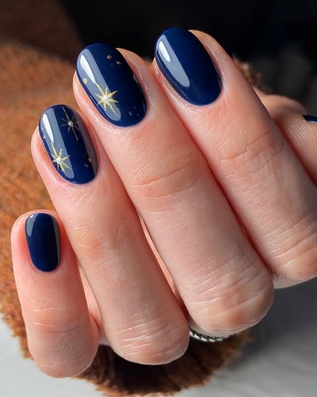 22. Midnight Blue Oval Nails with Gold Star Detail - dark color nail ideas