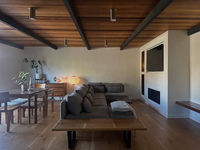 9. Mid-Century Calm with Exposed Ceilings and Clean Geometry - dark wood floor living room ideas