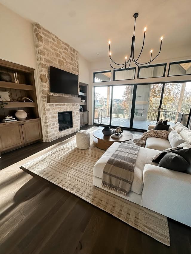 12. Rustic Stone Warmth with Sunlit Dark Floors - dark wood floor living room ideas