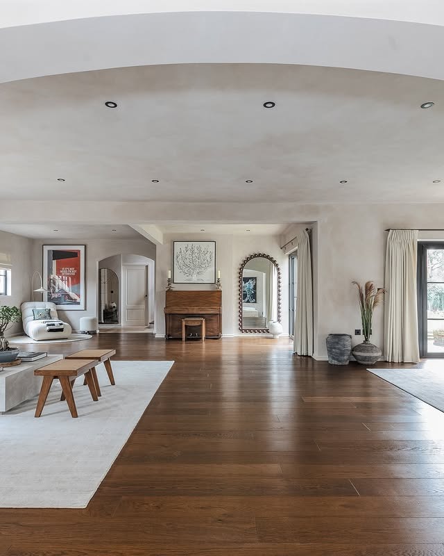 15. Open-Plan Warmth with Honeyed Wood and Curated Art - dark wood floor living room ideas