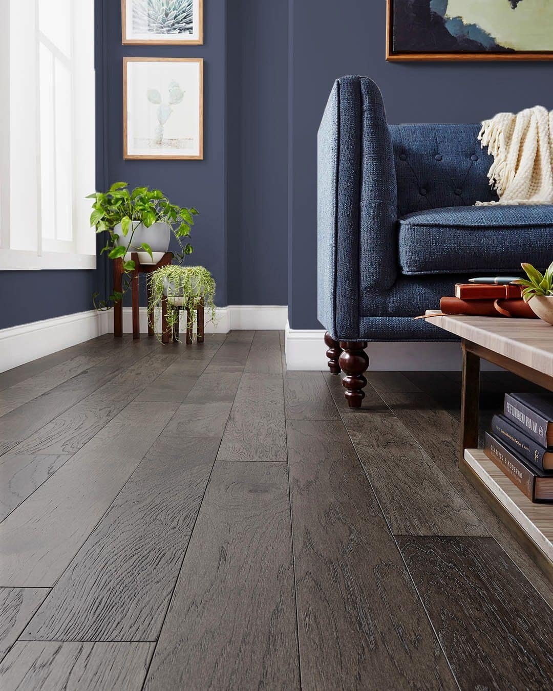 21. Deep Charcoal Flooring with Navy Walls and Textured Denim Seating - dark wood floor living room ideas