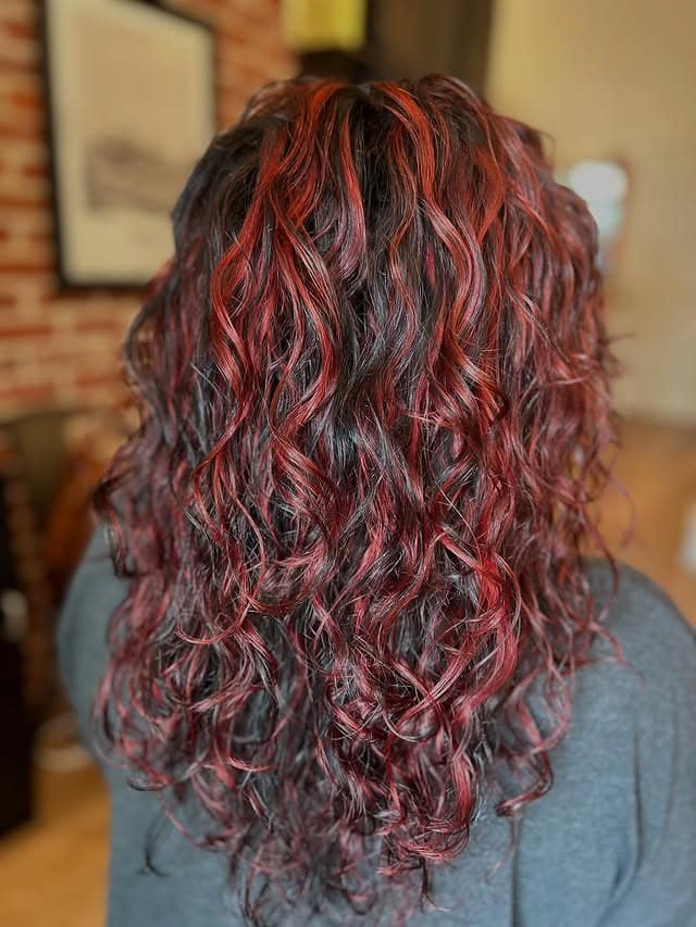 7. Crimson Ribbon Highlights on Natural Curls - Red Hair with Highlights