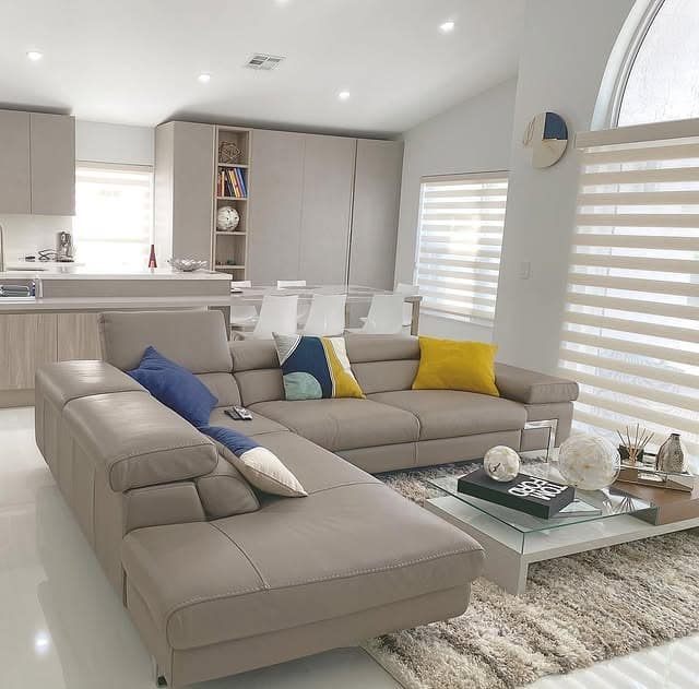 15. Modern Taupe Leather Sectional with Bold Color Pops - sectional living room ideas