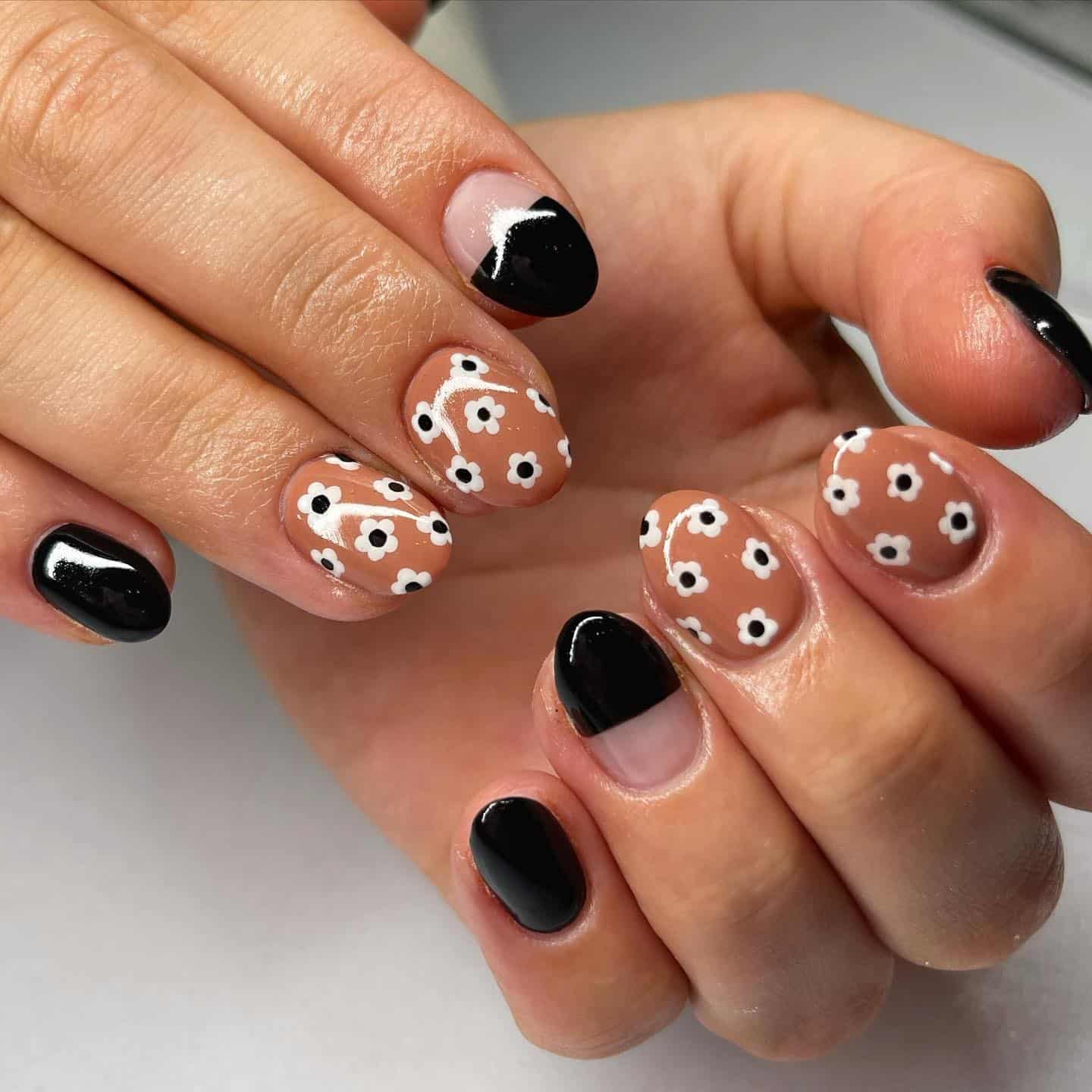 11. Black Daisy Accent Nails on Warm Tan Base - fall flower nail ideas