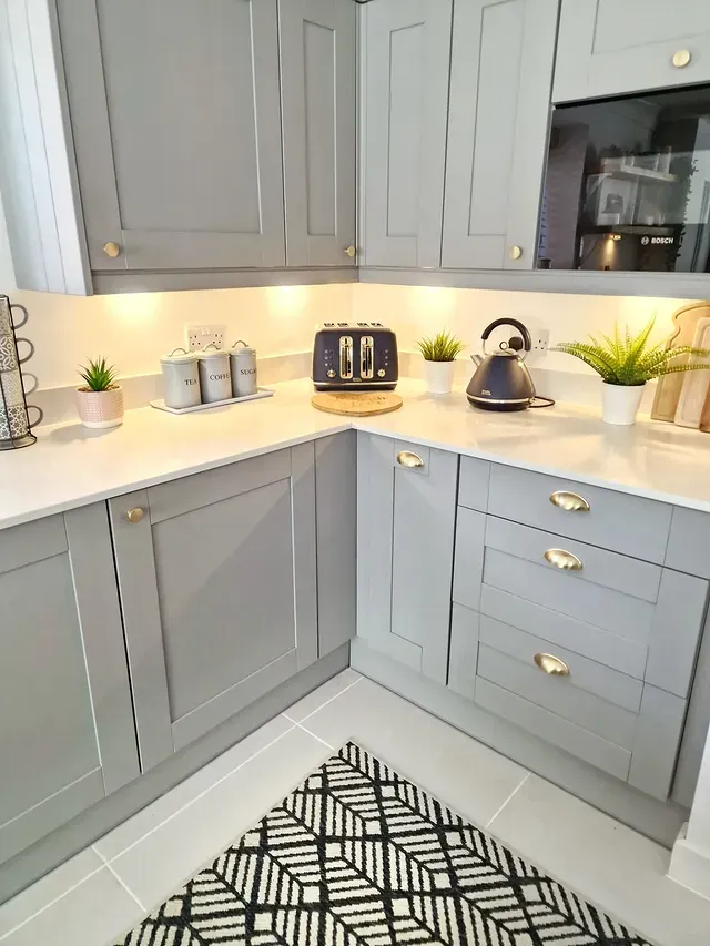 2. Soft Grey Corner Kitchen with Brass Finishes - yellow and grey kitchen ideas