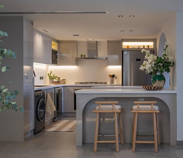 4. Minimalist Grey Kitchen with Curved Breakfast Bar - yellow and grey kitchen ideas
