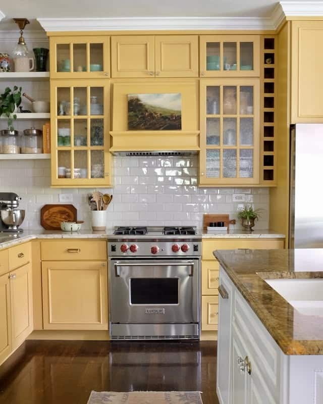 16. Traditional Glass-Front Yellow Cabinetry with White Tile and Grey Flooring - yellow and grey kitchen ideas