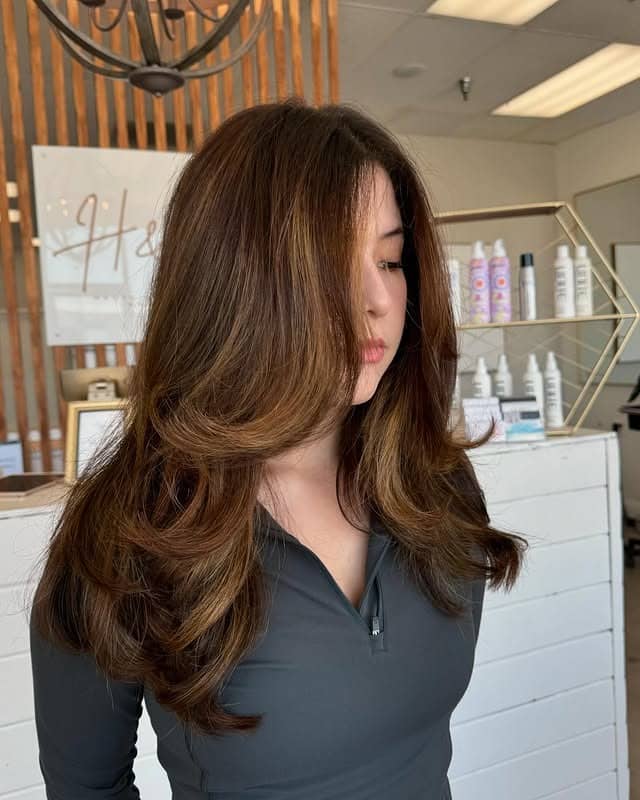 12. Warm Brunette Blowout with Feathered Contouring Layers - Face-Framing Haircuts