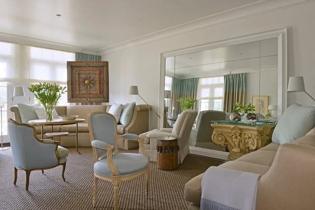 8. Grand Wall Mirror in Soft Beige with Sky-Blue Accents - mirrors in living room ideas