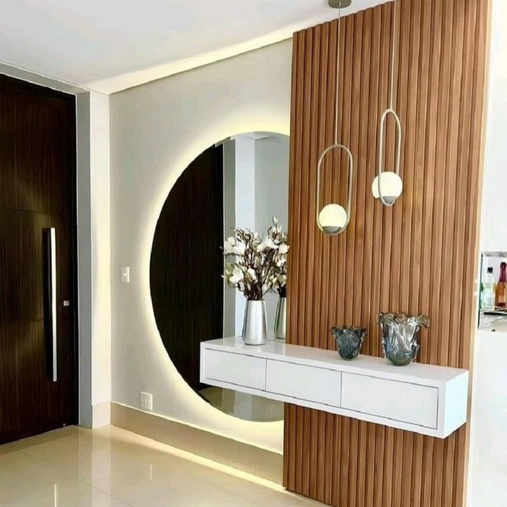 9. Backlit Circular Mirror with Wood Slatted Feature Wall - mirrors in living room ideas