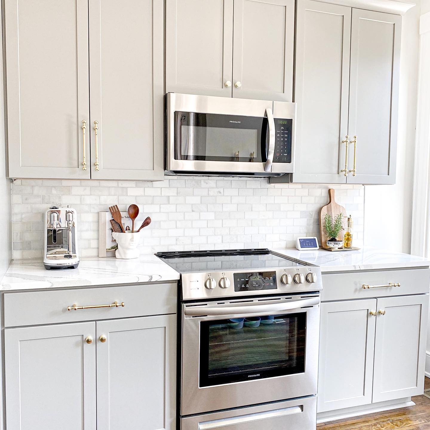 20. Light Gray Shaker Cabinets with Gold Hardware and Marble Detail - light gray kitchen ideas
