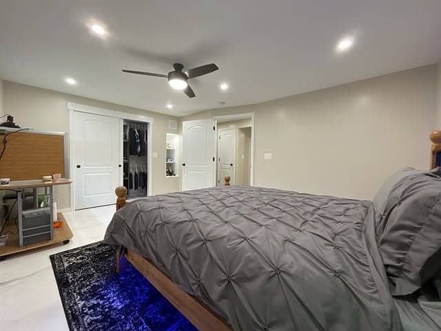 9. Modern Basement Suite with Sleek Lighting and Cool Neutrals - basement bedroom ideas