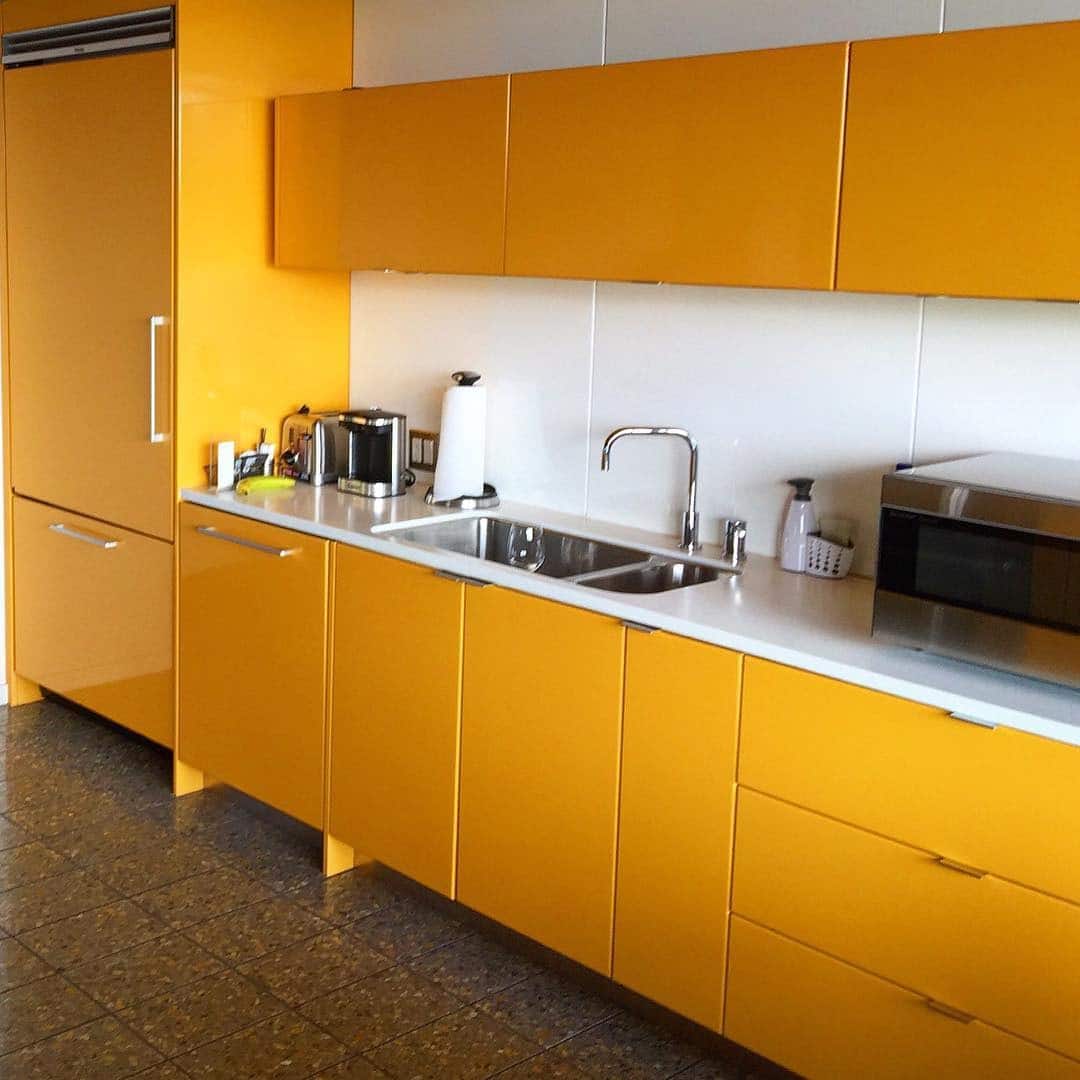 7. High-Gloss Amber Yellow Cabinets With Minimalist Appeal - yellow kitchen ideas