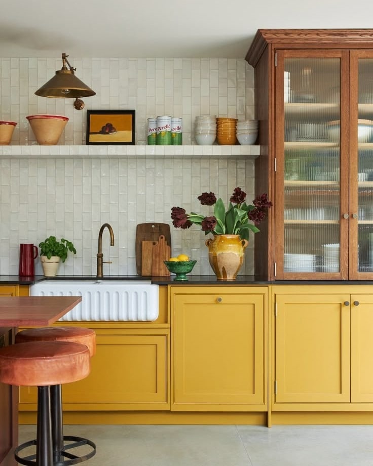 12. Golden Cabinetry Paired With Rich Wood and Textured Tile - yellow kitchen ideas
