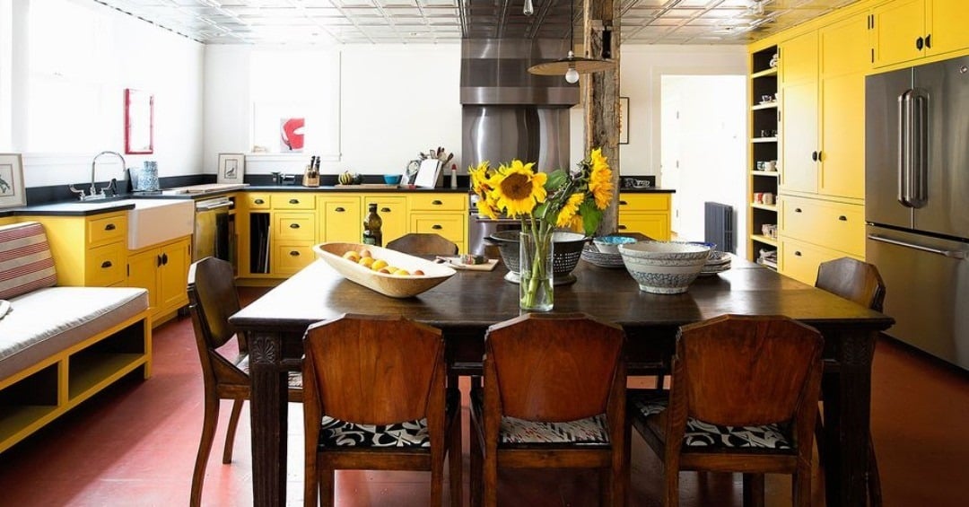 18. Farmhouse Dining Kitchen With Yellow Cabinetry and Rustic Elements - yellow kitchen ideas