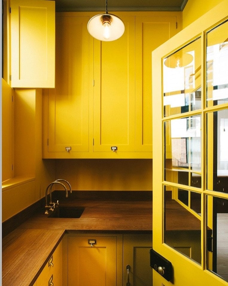 21. Compact Golden Kitchen With Warm Wood Countertops - yellow kitchen ideas
