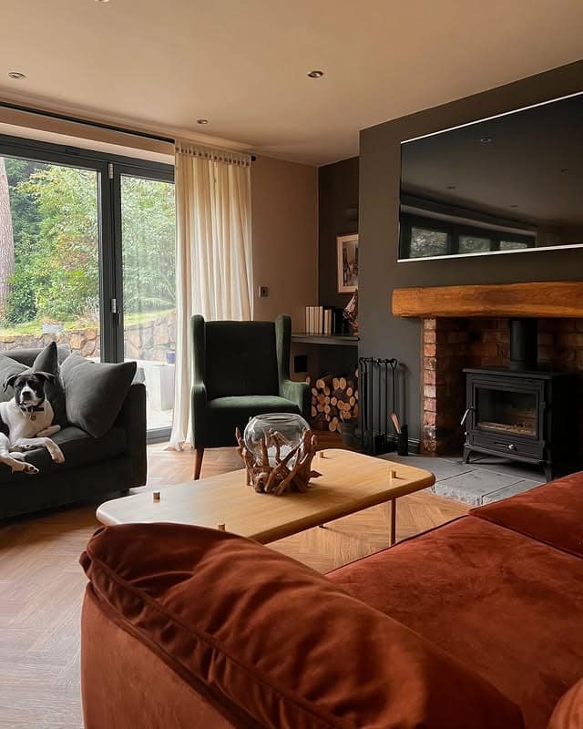 22. Burnt Sienna Sofa and Deep Earthy Tones by the Fireplace - dark brown living room ideas