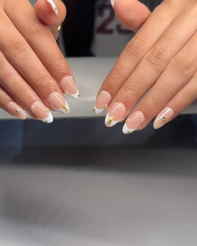 7. Subtle White French with Tiny Gold Stars - gold and white nail ideas