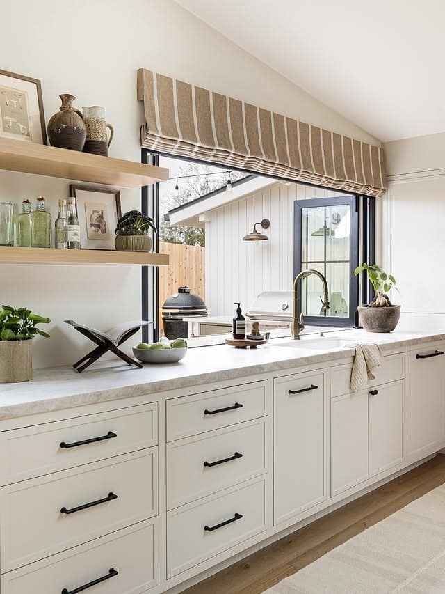 21. Creamy Cabinetry with Light Wood Floating Shelves - kitchen ideas with shelves