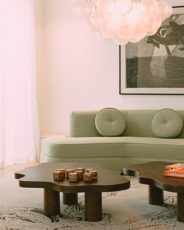 11. Soft Sage Curves with Sculptural Tables - green couch living room ideas