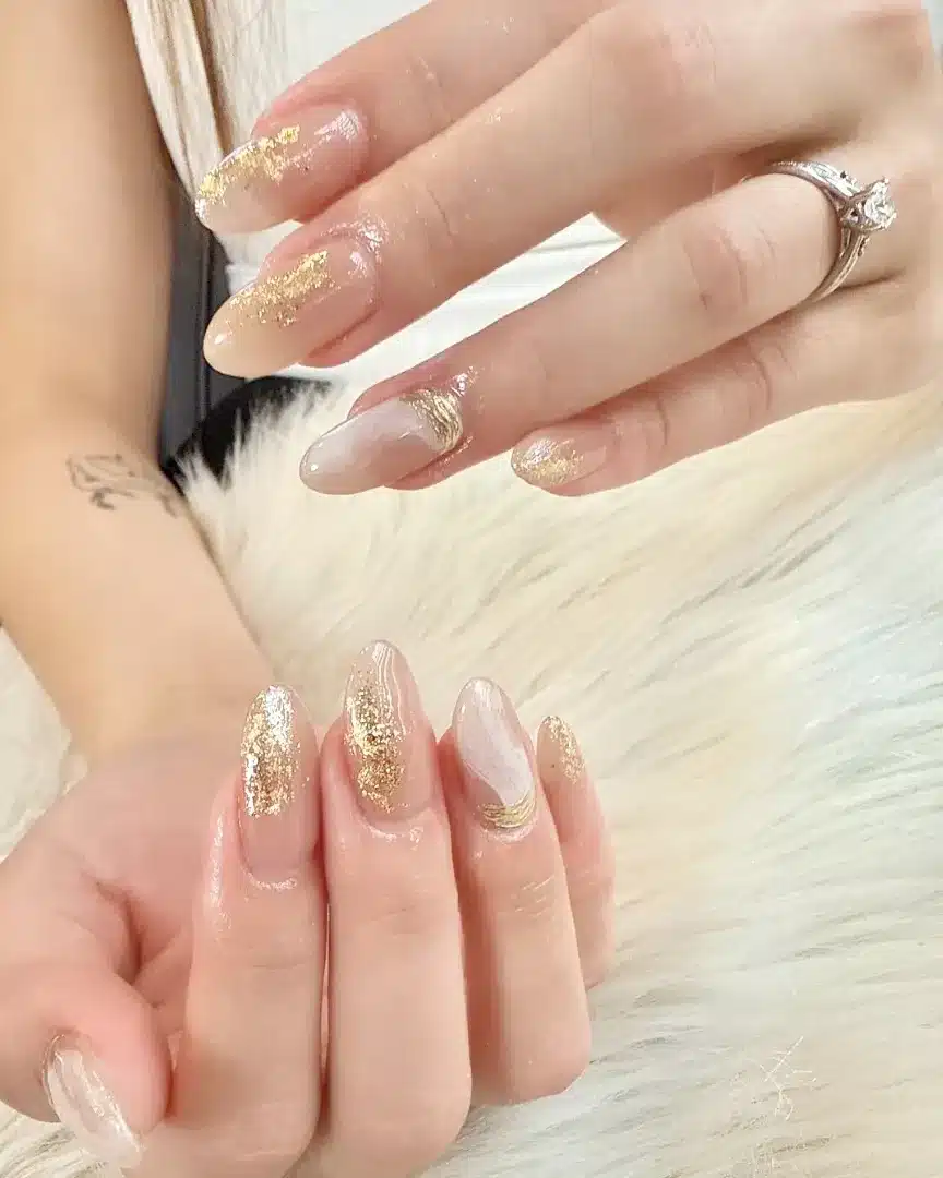 21. Soft Nude Almond Nails with Gold Foil Brush Accents - gold foil nail ideas