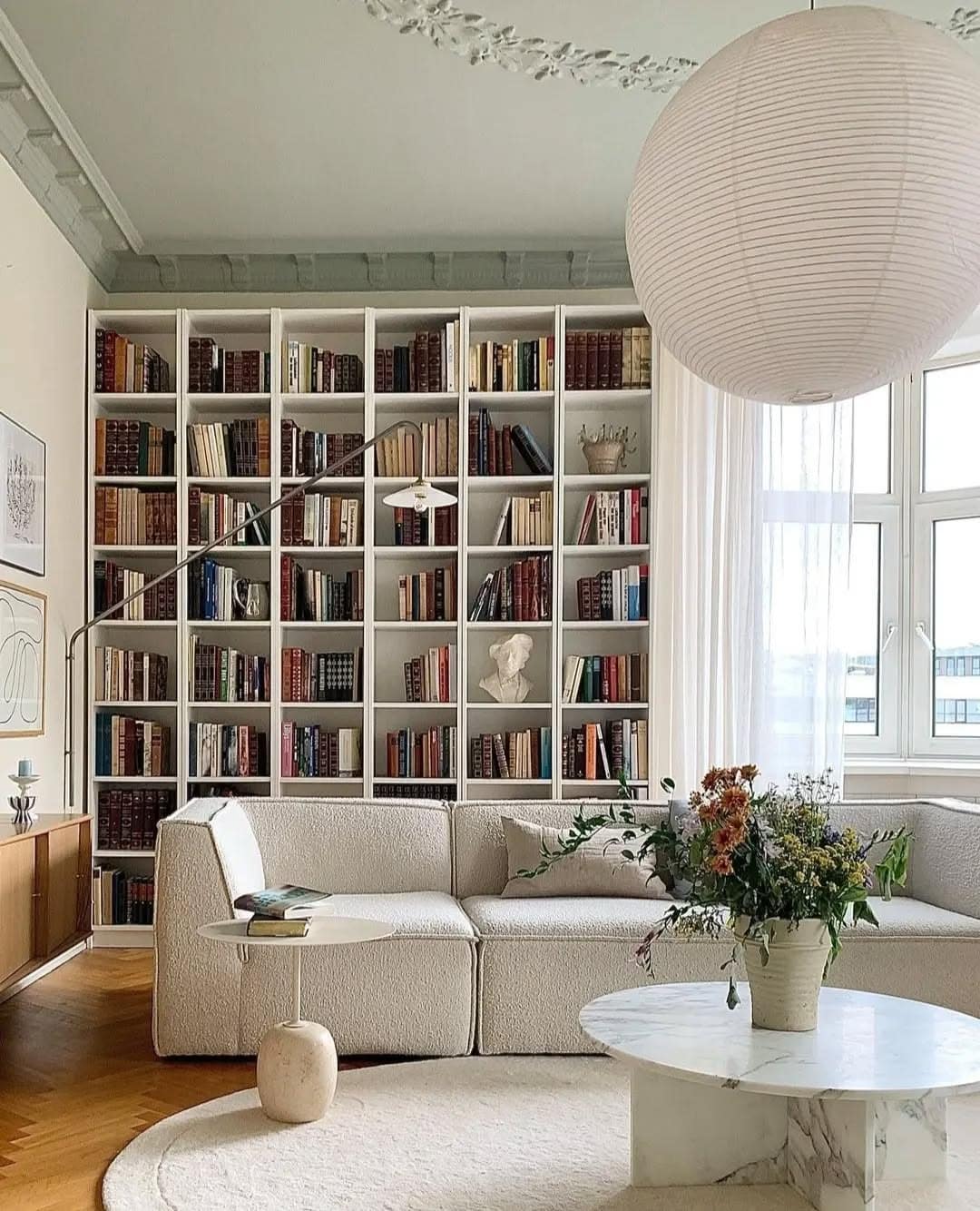 8. Classic Living Room with Cream Carpet and Library Wall - living room carpet ideas