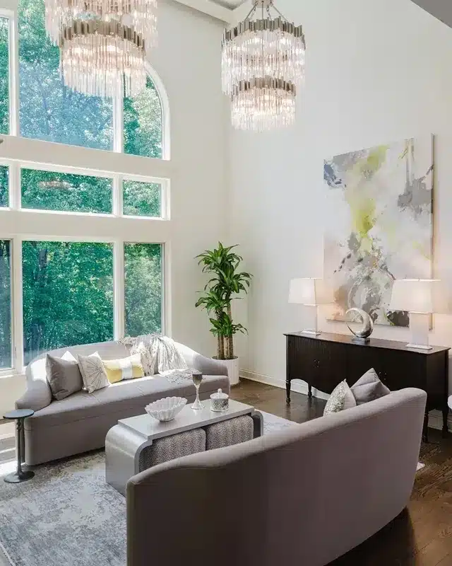 2. Modern Glam with High Ceilings and Crystal Lighting - glam living room ideas