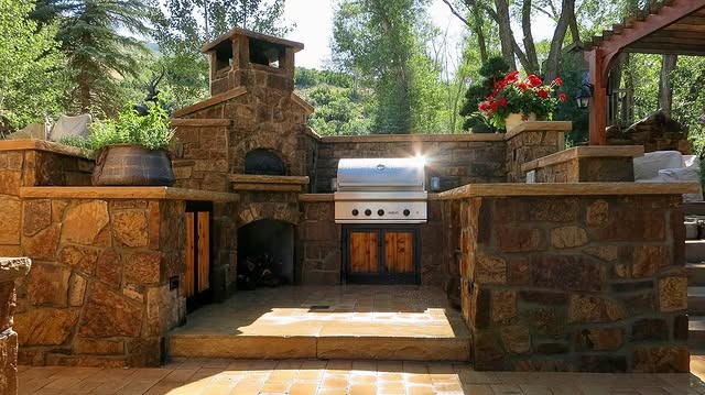 13. Courtyard-Style Outdoor Kitchen in Natural Stone and Sand - rustic outdoor kitchen ideas