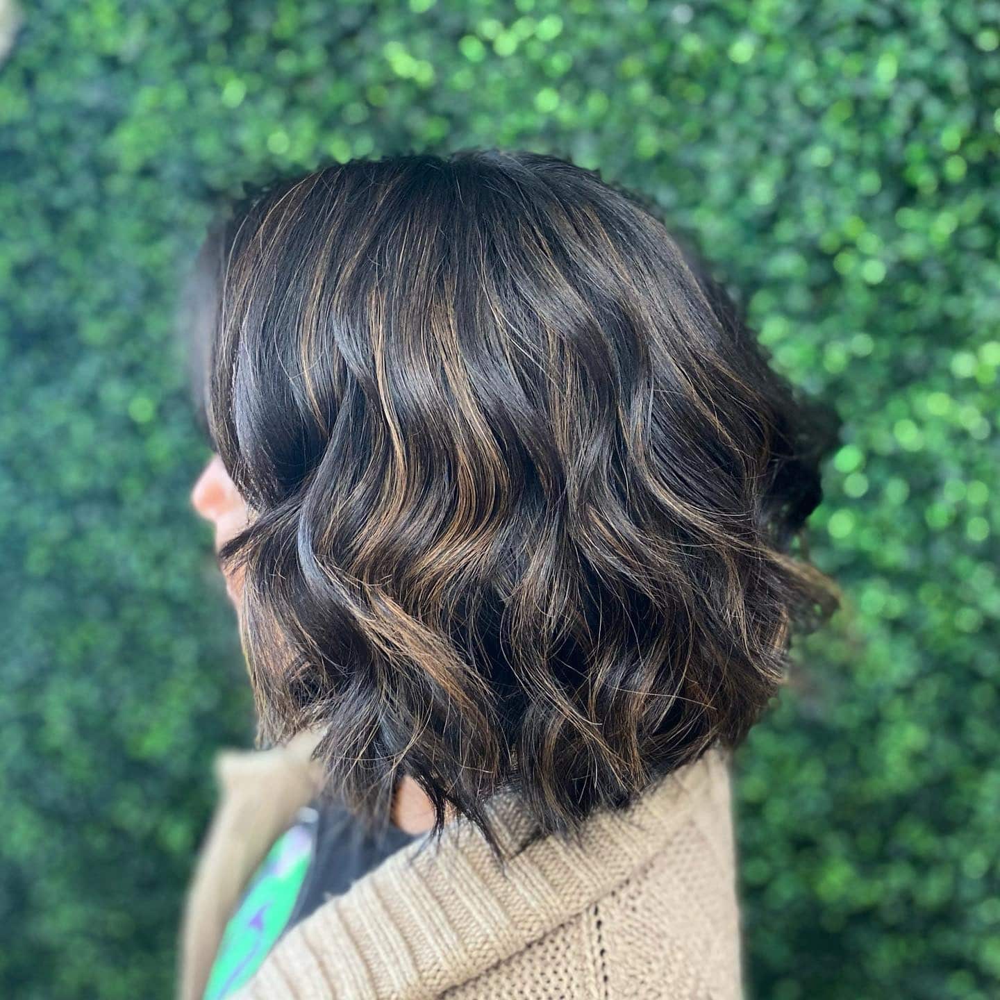 3. Textured Bob with Warm Caramel Ribbons - Black Hair with Highlights